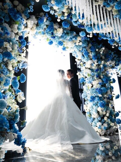 The couple beneath a floral wedding arch