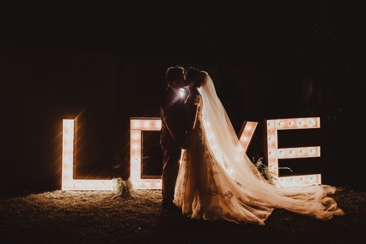 The couple in front of illuminated love letters