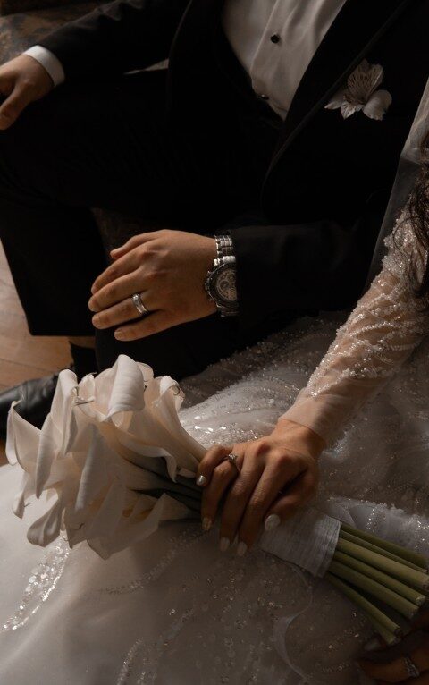 Close detail of the couple holding hands